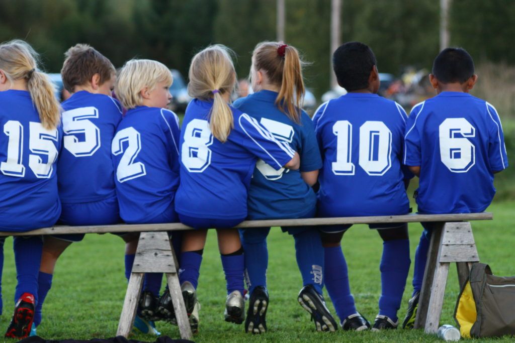 fotbollsspelande barn på en bänk