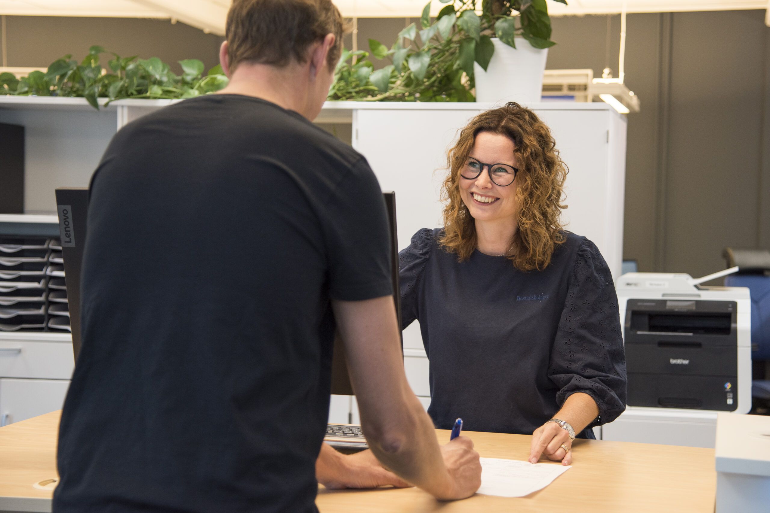 Personal från Bostadsbolaget tar emot besök och ler