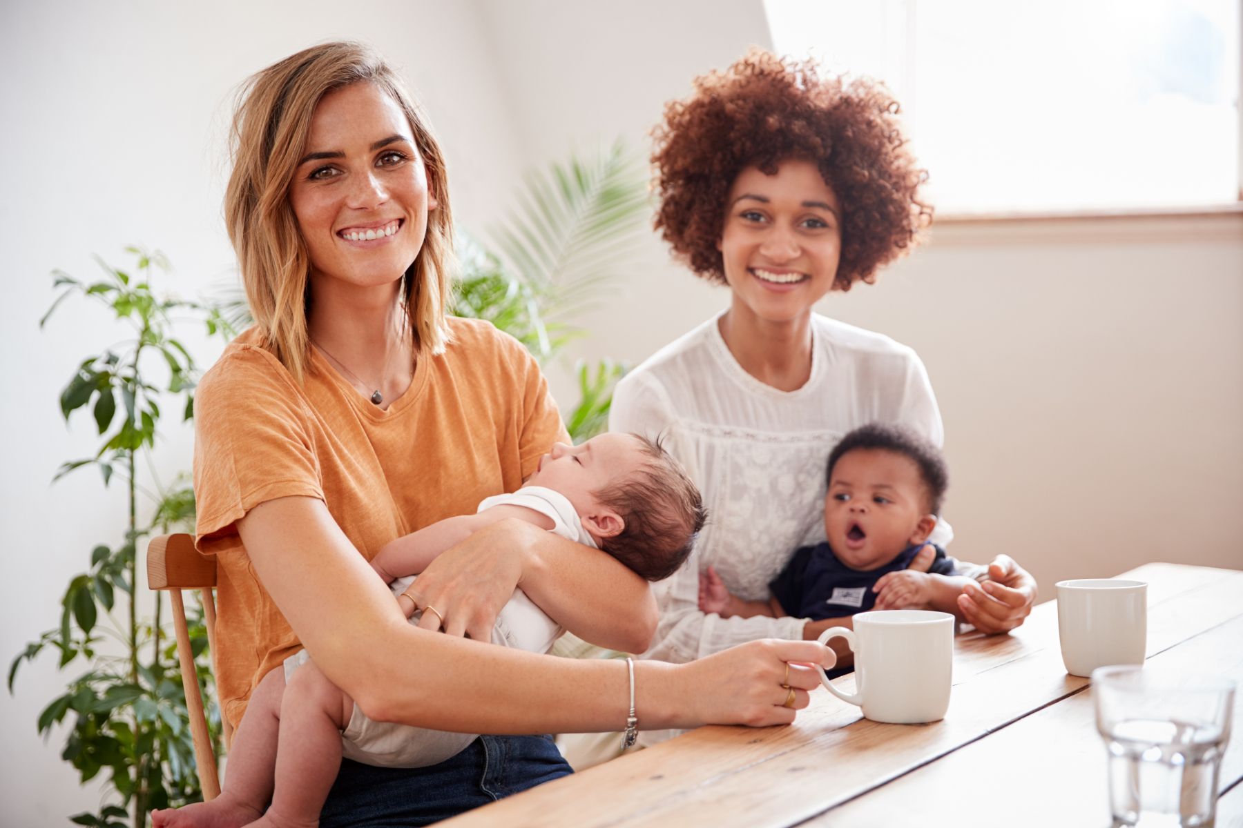 Två leende kvinnor med småbarn