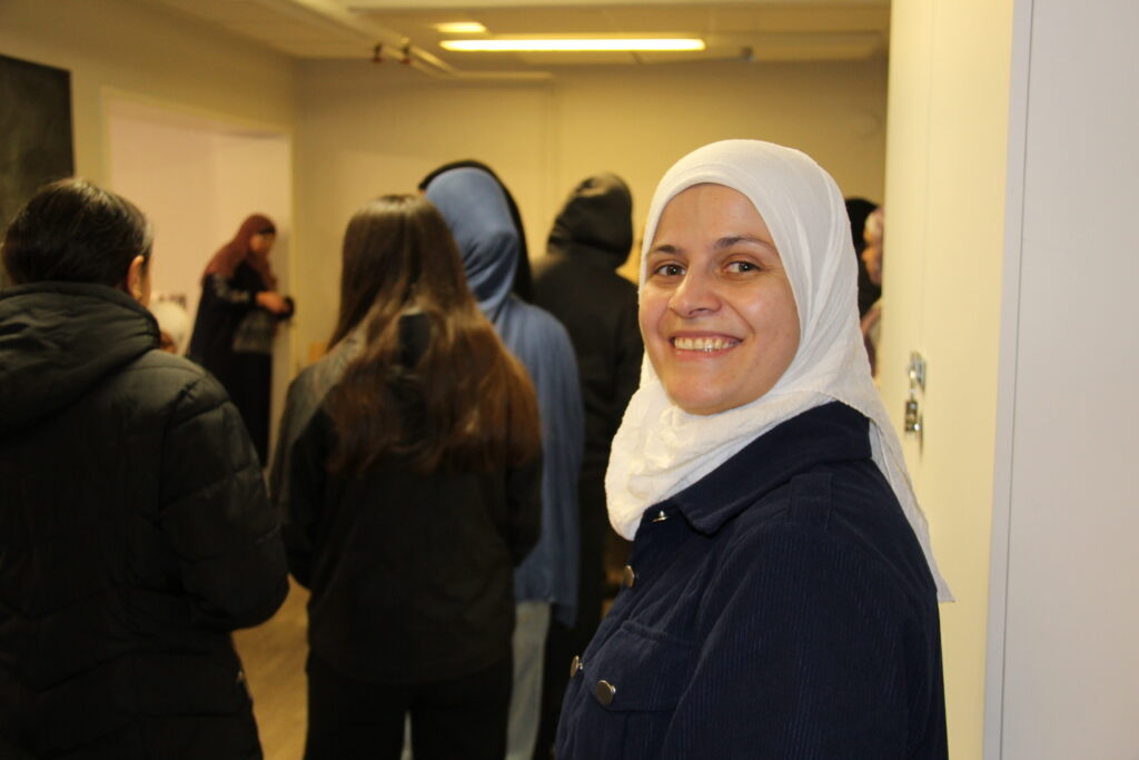 glad kvinna i slöja framför en kö av människor