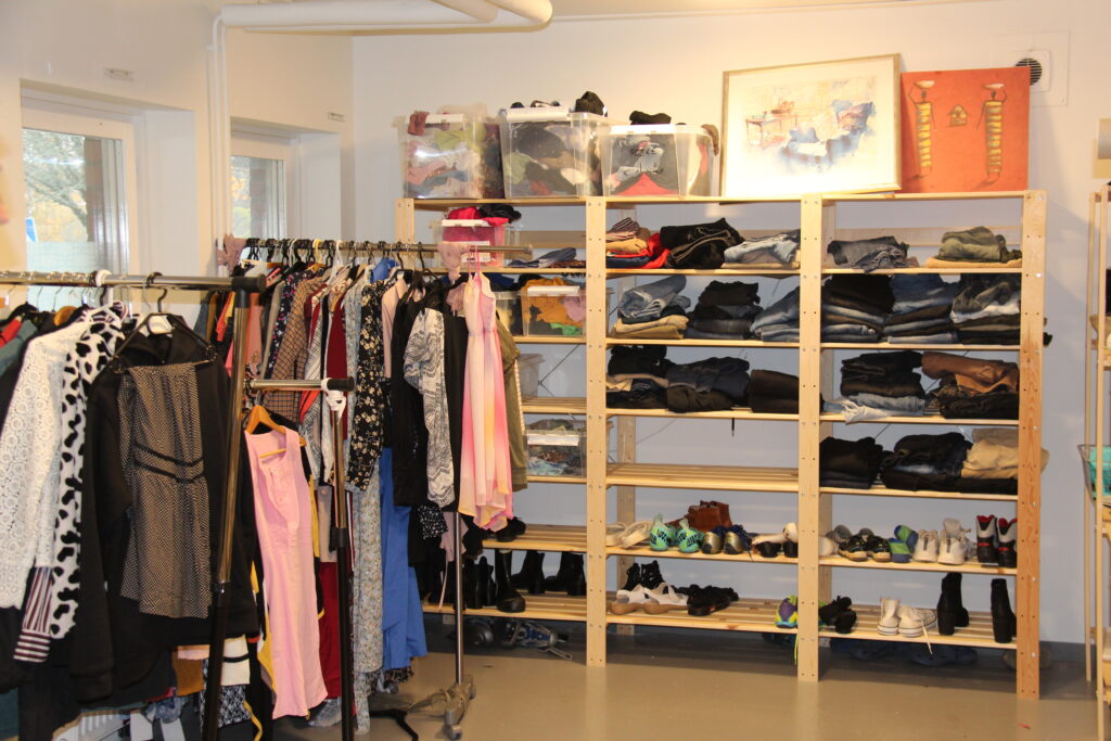 Kläder och saker på hyllor i en lokal