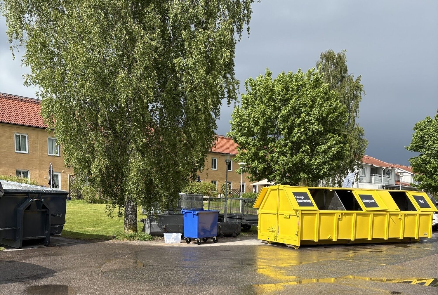 gul container framför hyreshus
